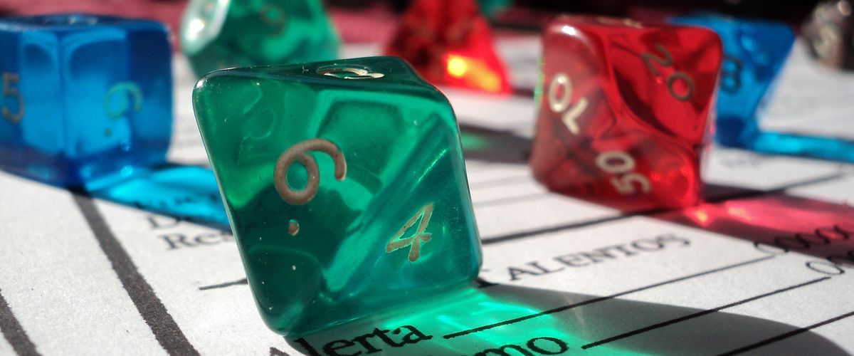 Colorful polyhedral dice resting on a character sheet during a tabletop role-playing game session